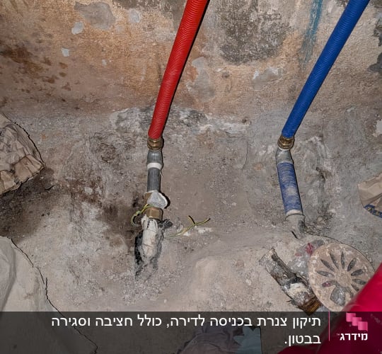 צינורות מים אדומים וכחולים על קיר בטון